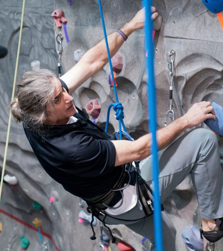 Member climbing the indoor rock wall at Hawthorn Farm Athletics in Hillsboro, Oregon.